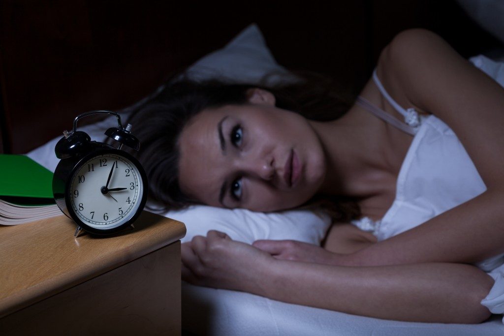 woman staring at her alarm clock