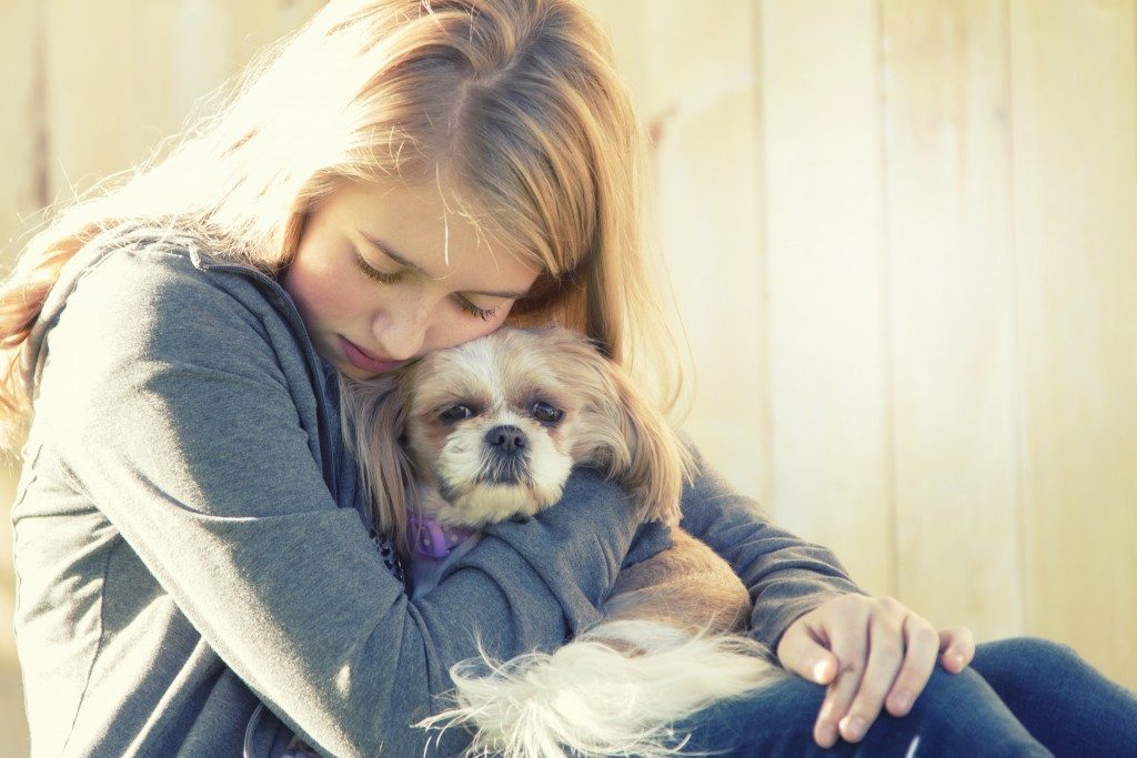 Sad female hugging dog