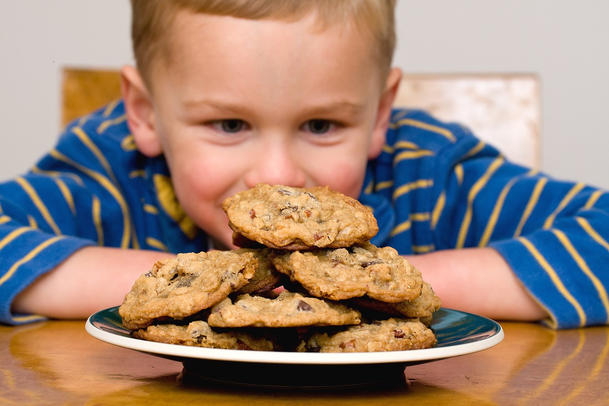 kid looking at a plate of cookies