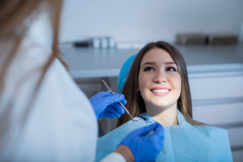 a young woman sitting on a dental chair getting teeth checked