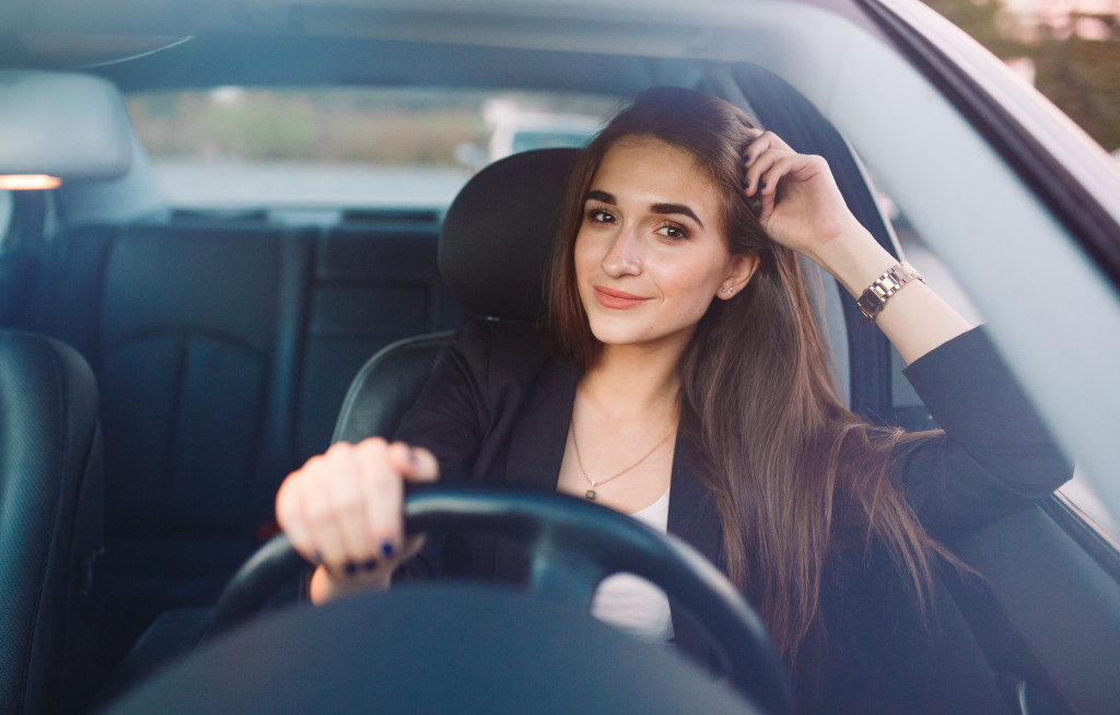 An attractive woman smiling in her car