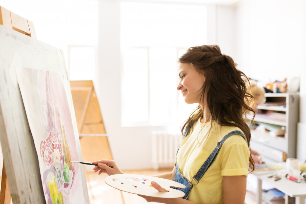 young woman happily painting art