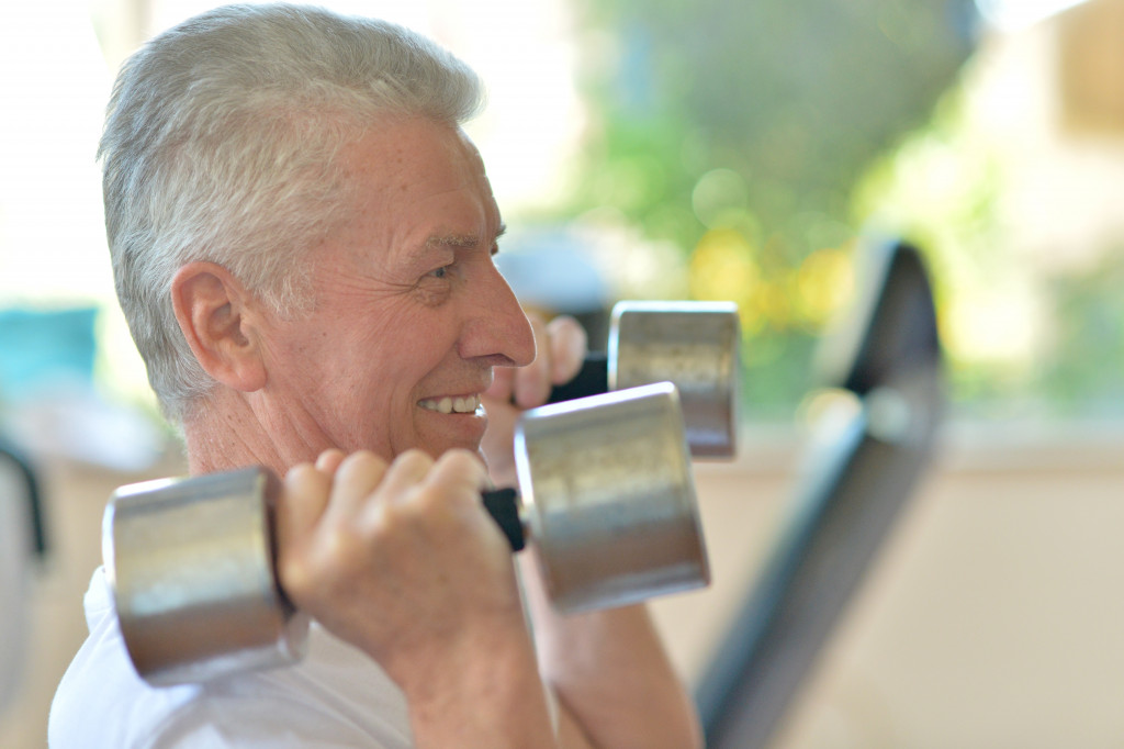 an elderly man smiling while working out