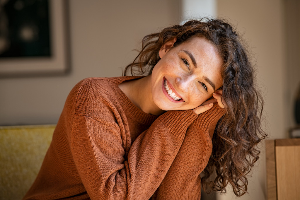 curly hair woman smiling with freckles