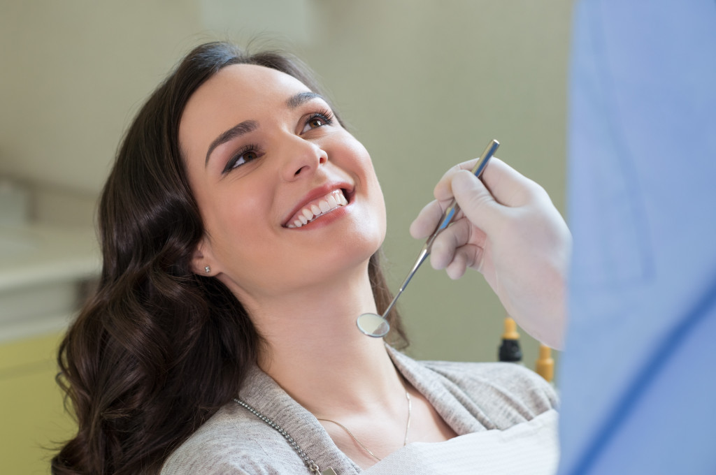 woman smiling at dentist holding apparatus