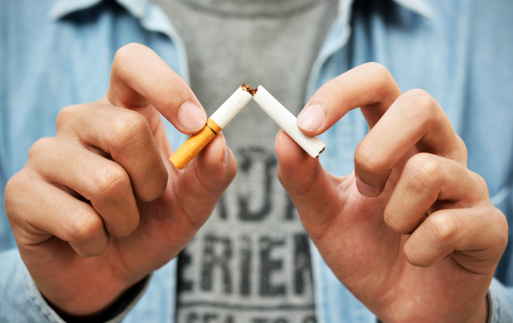 man breaking cigarette in half