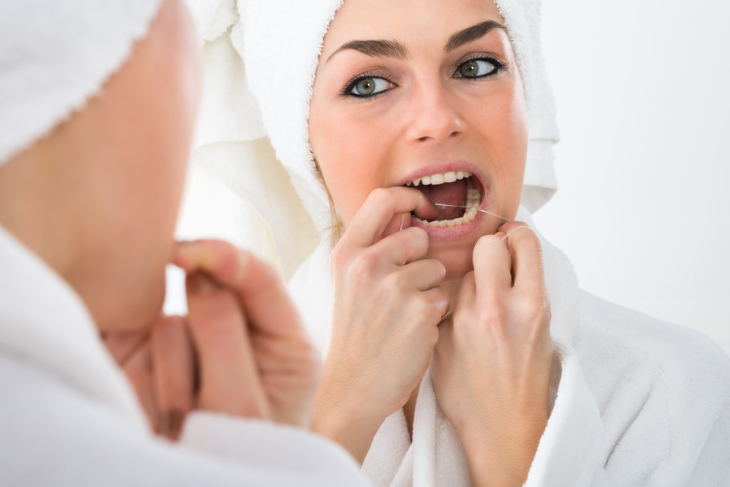 woman flossing in bathroom