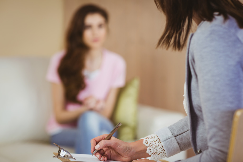 woman talking to therapist taking down notes